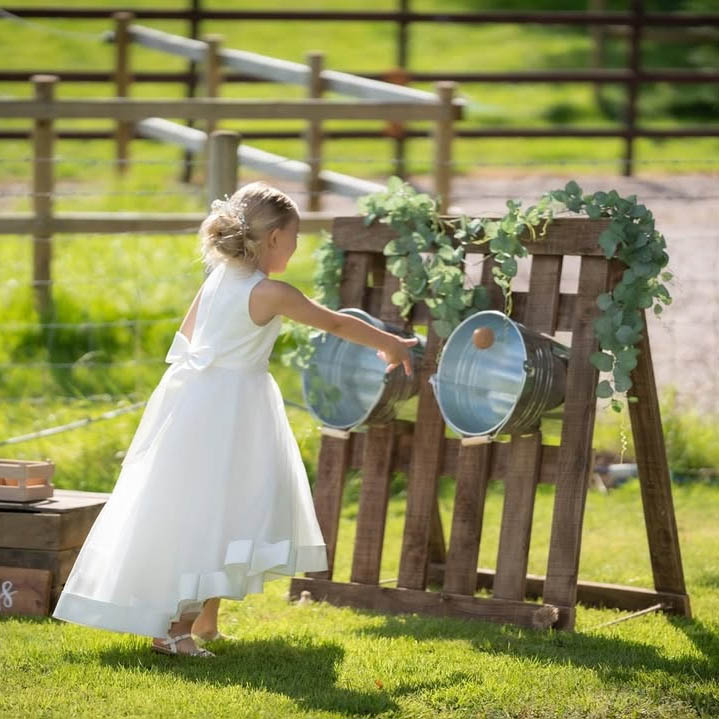 Bucket Toss: Handcrafted vertical Bucket Toss game where guests aim bean bags into tiered wooden buckets.