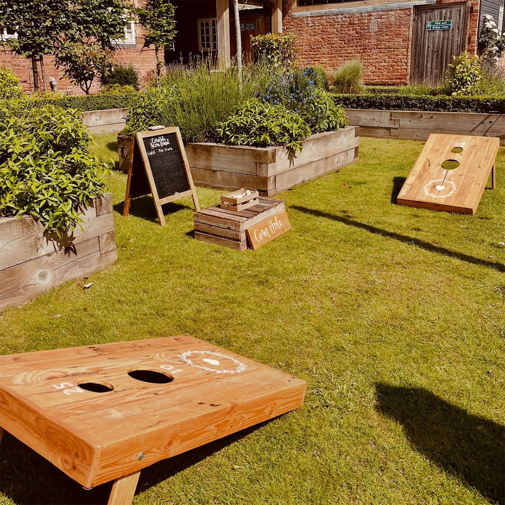 Cornhole: Handcrafted wooden Cornhole boards with bean bags, perfect for team competitions at garden parties.