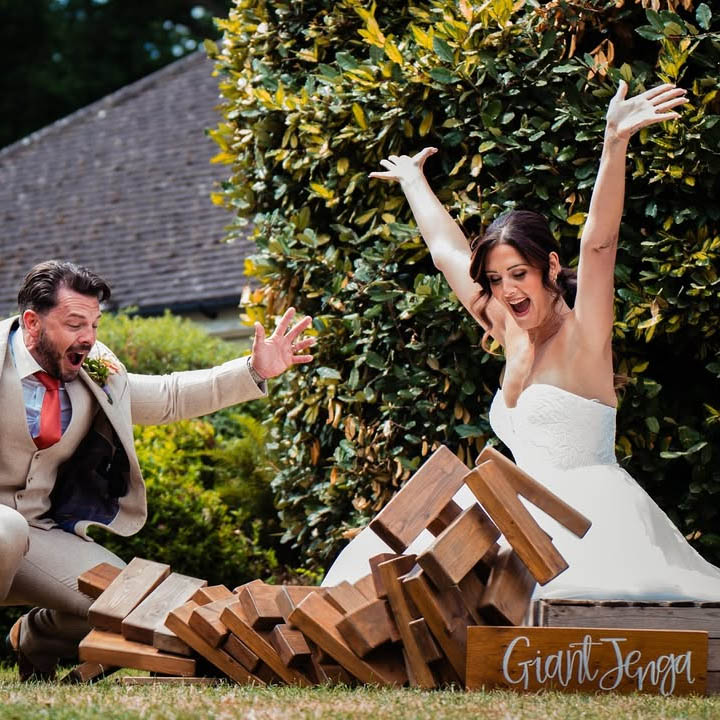 Giant Jenga: Towering wooden Giant Jenga set stacked and ready for play at a summer garden party.
