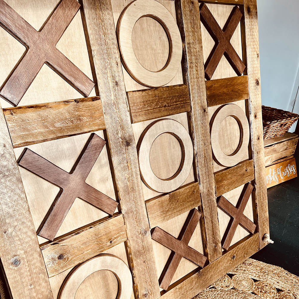 Giant Noughts & Crosses: Rustic wooden Giant Noughts and Crosses board with chunky game pieces for a wedding reception.
